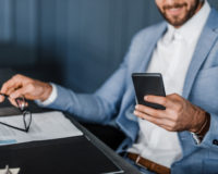 businessman typing out text on smartphone