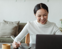 woman smiling while working at laptop