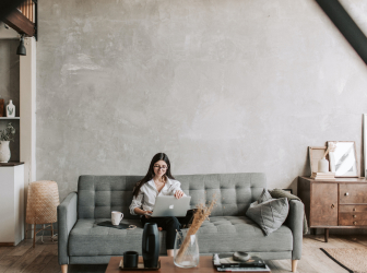 woman working on her laptop while sitting on a couch