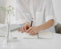 woman taking notes about how to grow a real estate brokerage