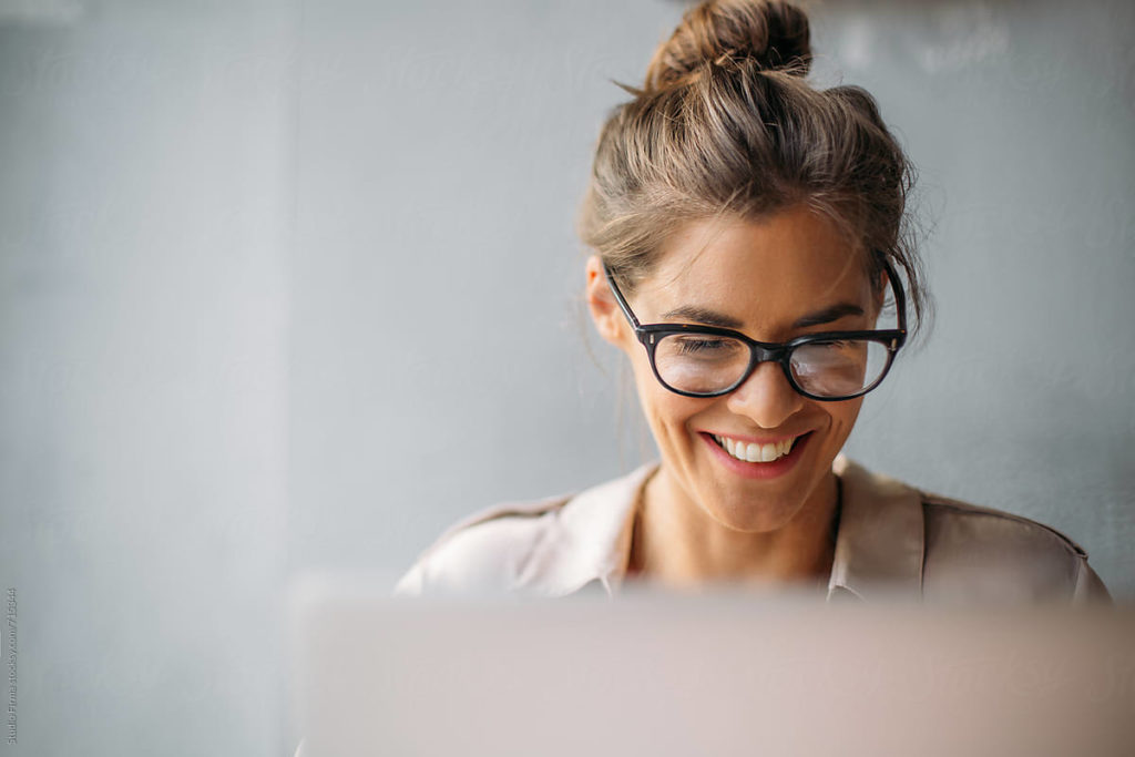 woman smiling while using laptop