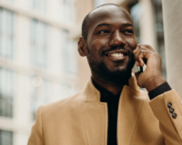 man smiling while talking on cell phone